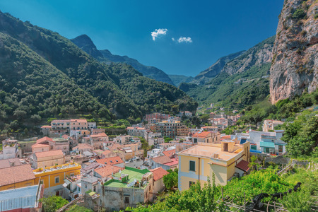 View of the houses of the town of Amalfi, Italy, under mountains and blue skyの写真素材