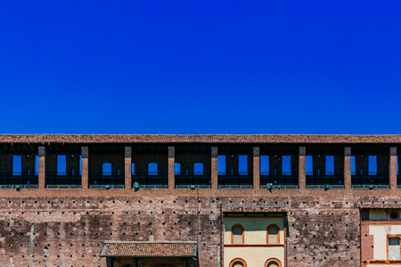 View of the wall of Sforzesco Castle under blue sky in downtown Milan, Italyのeditorial素材