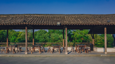 View of chairs and tables in covered walkway in the old town of Wuzhen, Zhejiang, Chinaの写真素材