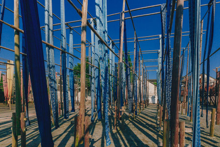 View of blue cloth hanging over wooden poles in a square in the old town of Wuzhen, to showcase...