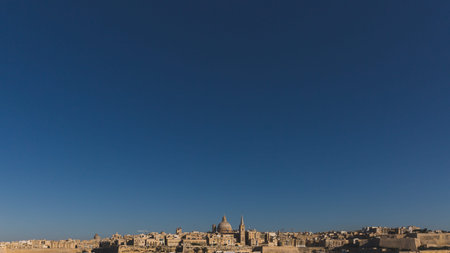 View of skyline of Valletta, Malta under blue sky, with dome of Basilica of Our Lady of Mount Carmel...