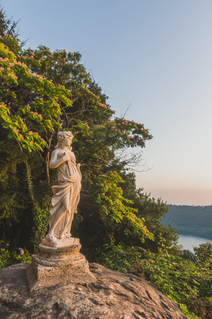 View of Lake Nemi and hills with statue on rock, from the town of Nemi, south of Roma, Italyの写真素材