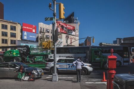 April 16, 2019 - New York City, USA: Woman waiting to cross street in Manhattan Chinatownのeditorial素材