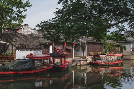 Traditional Chinese architecture by water with boats on river in old town of Nanxun, Zhejiang, Chinaのeditorial素材