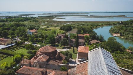 View of island of Torcello with churches and buildings, from bell tower of Cathedral of Santa Maria Assunta, in Torcello, Venice, Italyの写真素材