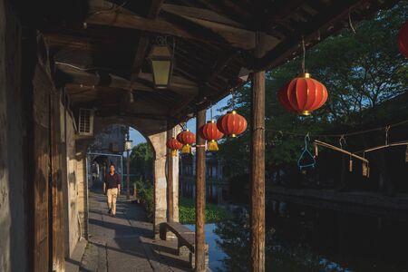 Nanxun, Zhejiang, China - 24 May 2019: Old Chinese local man walking down street passing traditional Chinese architecture in Nanxun Old Townのeditorial素材