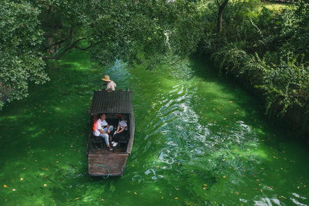 Suzhou, China - 25 August 2019: Traditional hand-rowing boat traveling on river in Tiger Hill (Hu...