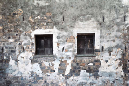 Two windows on wall of old traditional Chinese houseの写真素材