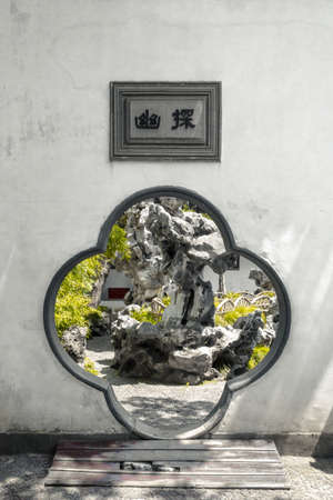 Flower-shaped gate at Lion Grove Garden (Shizilin), with plaque saying "exploring the hidden", in Suzhou, Chinaのeditorial素材