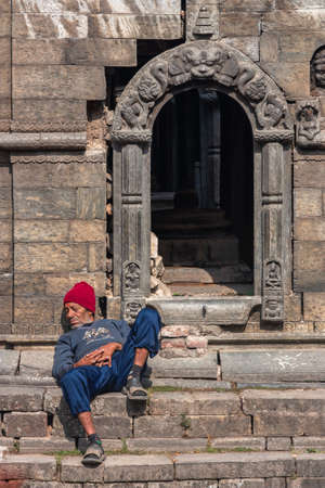 Kathmandu, Nepal - January 2011: homeless man sleeping near temple entranceのeditorial素材