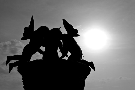 Black and white cupids against the skyの写真素材
