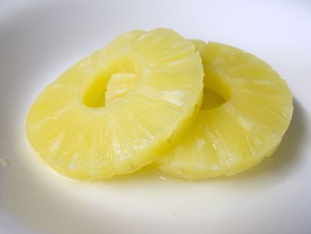 Slices of pineapple on a white plateの写真素材