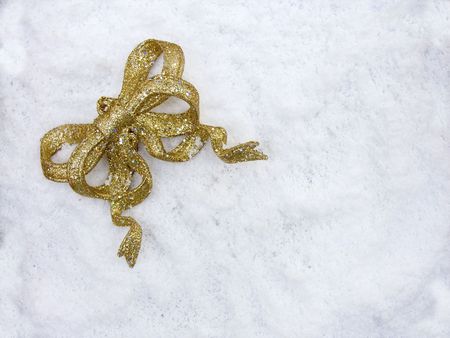 A gold glittery christmas deocration ribbon on snowの写真素材
