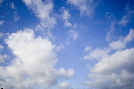 Vivid blue sky with fluffy cloudsの写真素材