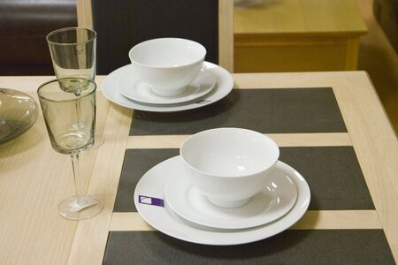 Two formal white teacups on saucers