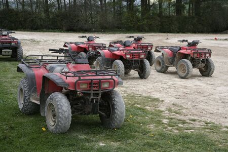 A group of dirty quad bikes waiting to be riddenの写真素材