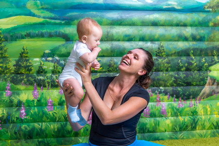 Mother with baby doing gymnastics. Fun mood.の写真素材