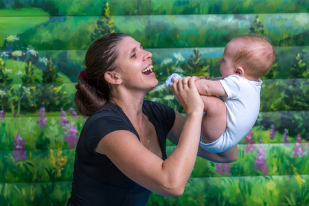 Mother with baby doing gymnastics. Fun mood.の写真素材