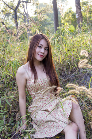 Asian girl sitting in a fieldの写真素材