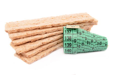 crispbread with measuring tape on a white backgroundの写真素材