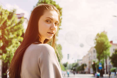 Woman walking on the street and turn around,looking to the camer