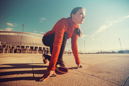 Fitness athlete on starting near stadium track preparing for a sprint. Fitness, healthy lifestyle conceptの写真素材