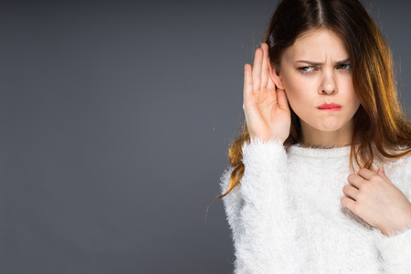 Shocked angry office worker eavesdropping. Hearing gesture shock emotion concept. Young nerdy stunned lady in glasses listening expressing disbelief gasping.の写真素材