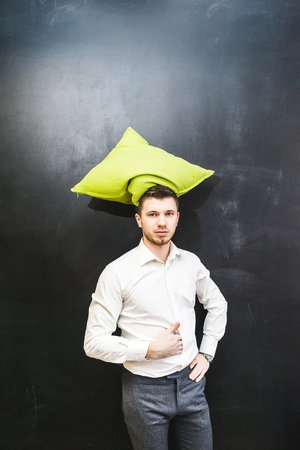 funny professor or teacher with pillow like a hat on the headの写真素材