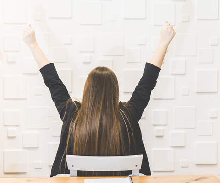 Happy excited office woman with raised arms win finish concept.Great job!Back viewの写真素材