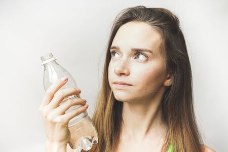 Young sporty girl showing a bottle of water. Isolated on white backgroundの写真素材