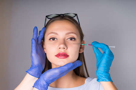 Portrait of a young beautiful woman who make injections of beauty, Botox on the lips and faceの写真素材