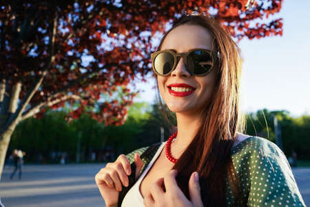 Fashion woman in glasses on street style with bag,sunset.Dental.の写真素材