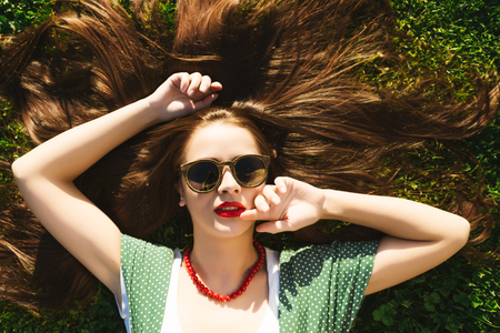 Young fashion summer girl in dress lying on grass.View above,retro,vintageの写真素材