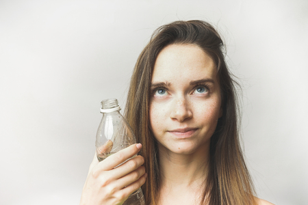 Happy woman with bottle looking up isolatedの写真素材