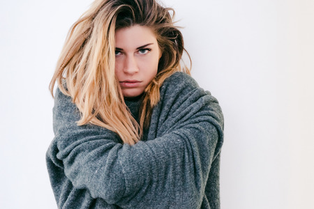 Aggressive girl in depression, sick and dressed in a sweaterの写真素材