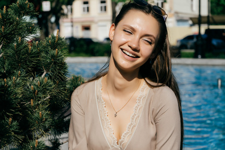 girl with long hair smiling at the pool backgroundの写真素材