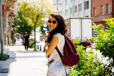Happy tourist woman in glasses walking in New York street, turn around,exploring cityの写真素材