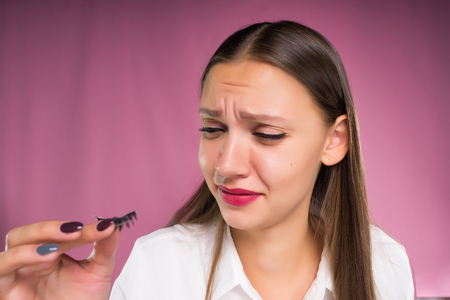 a young girl is upset by her false eyelashesの写真素材