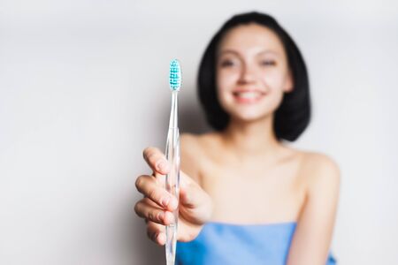 a girl after a shower is about to brush her teeth, a blue toothbrushの写真素材