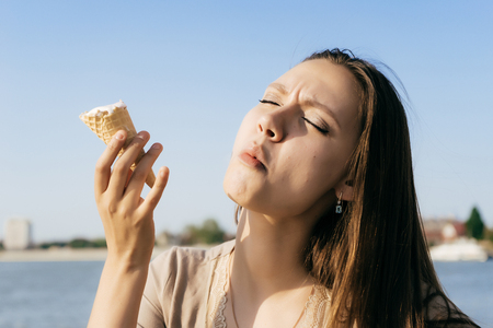 surprised girl walks and eats ice creamの写真素材