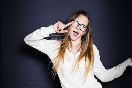 funny girl with big glasses writhes her face, isolatedの写真素材