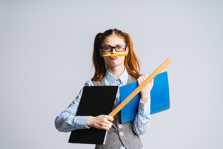 Cheerful funny schoolgirl student. The teacher is entertained, in a suitの写真素材