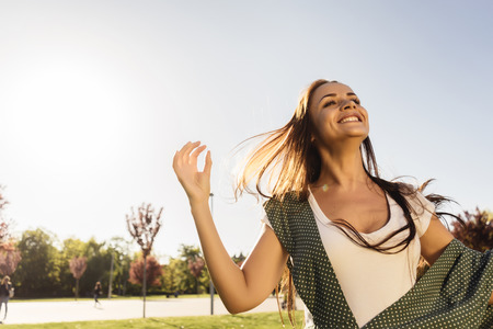 Free Happy Woman Enjoying Nature. Beauty Girl Outdoor. Freedom concept. Beauty Girl over Sky and Sun. Sunbeams. Enjoyment.の写真素材
