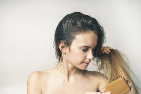 woman brushing her hair with enjoy on a white backgroundの写真素材