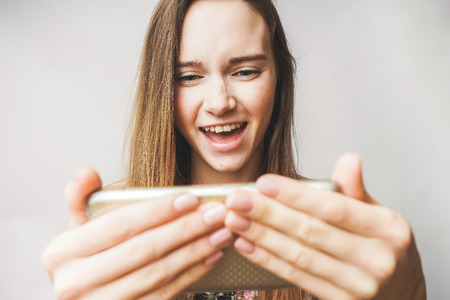 young girl playing games in mobile phone, addicted,selfieの写真素材