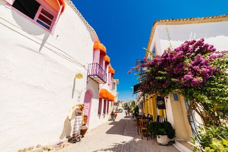 fashionable girl in a long dress is standing by the wall in an ancient cityの写真素材