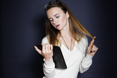girl student pensively looking at file in her handの写真素材