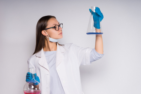 girl chemist studying the contents of the flasksの写真素材