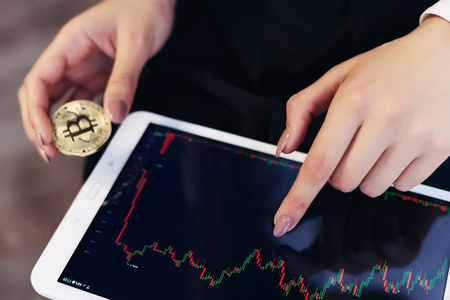 a girl with a tablet in her hands follows the exchange rate