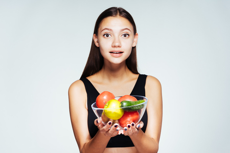 cute girl about to cook a vegetable salad and looks directly at the camera, isolated, healthy food, healthy lifeの写真素材